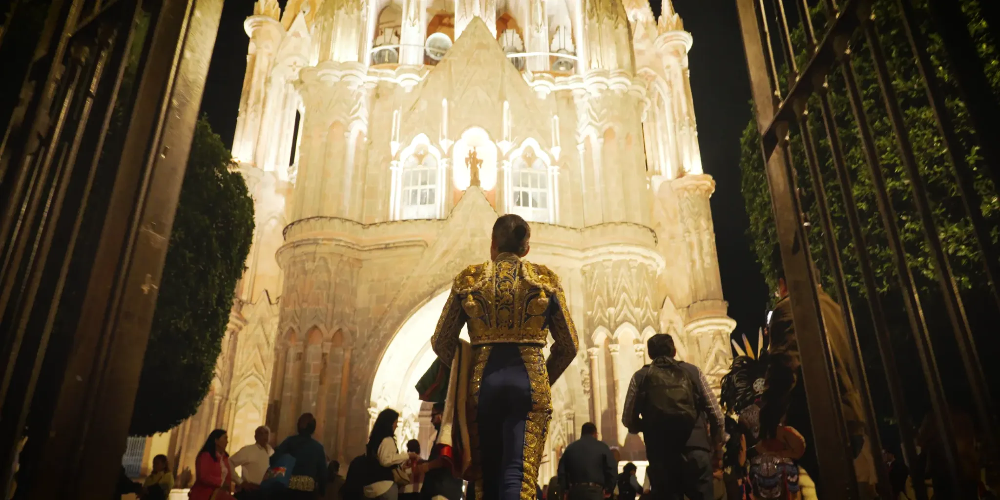 A bullfighter approaching an illuminated cathedral